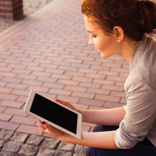 woman holding white iPad